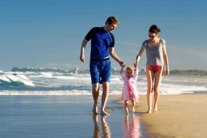 Couple and daughter walking on the beach.