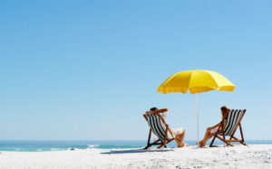 View of people relaxing at Fort Myers beaches under an umbrella
