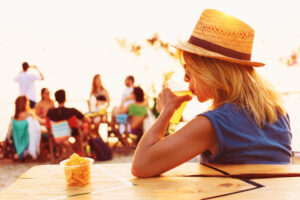 Person sipping a tropical drink by the beach: one of the top things to do in Fort Myers Beach