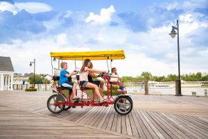 Family riding on a bike at Lakes Park, one of the best things to do in Fort Myers with kids