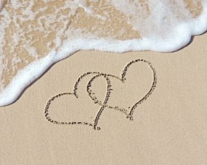 Hearts drawn on the sand during romantic beach getaways in Florida